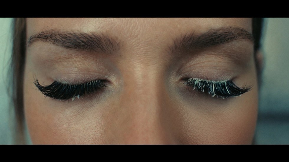 Close-up of cyanoacrylate blooming effect causing fine white powder on lash extensions overnight